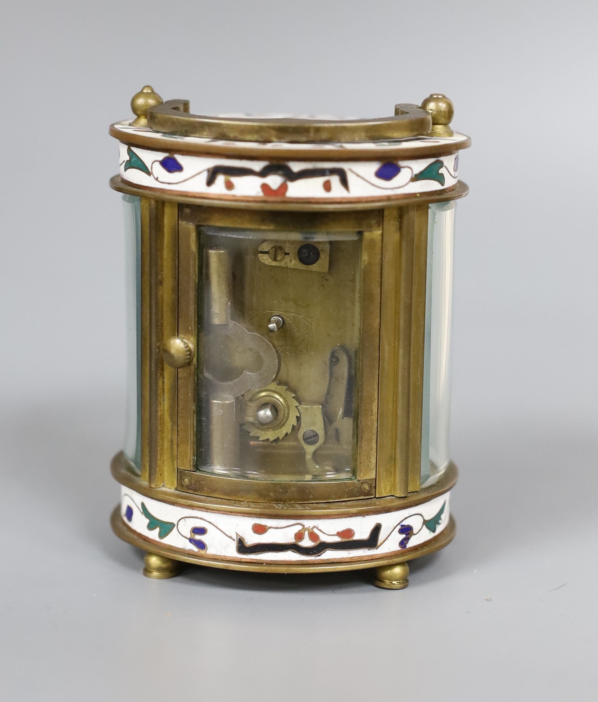 An oval brass and champleve enamel carriage timepiece, 9cm